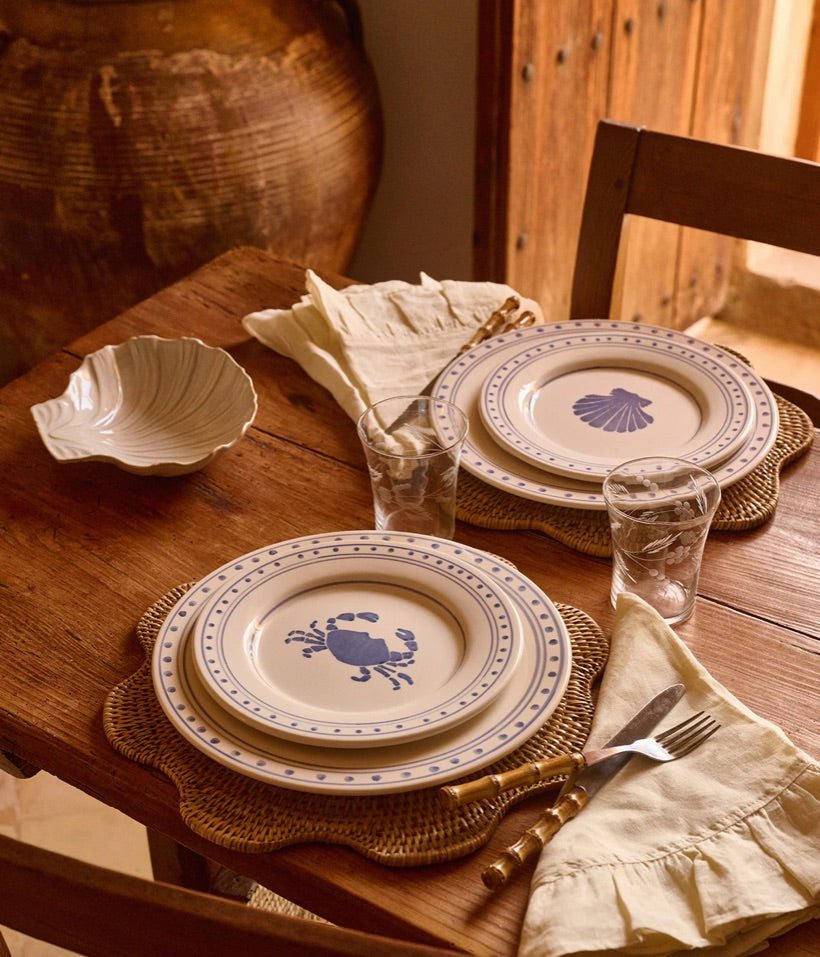 Tallrikar med blå detaljer på ett träbord med vackra färger
