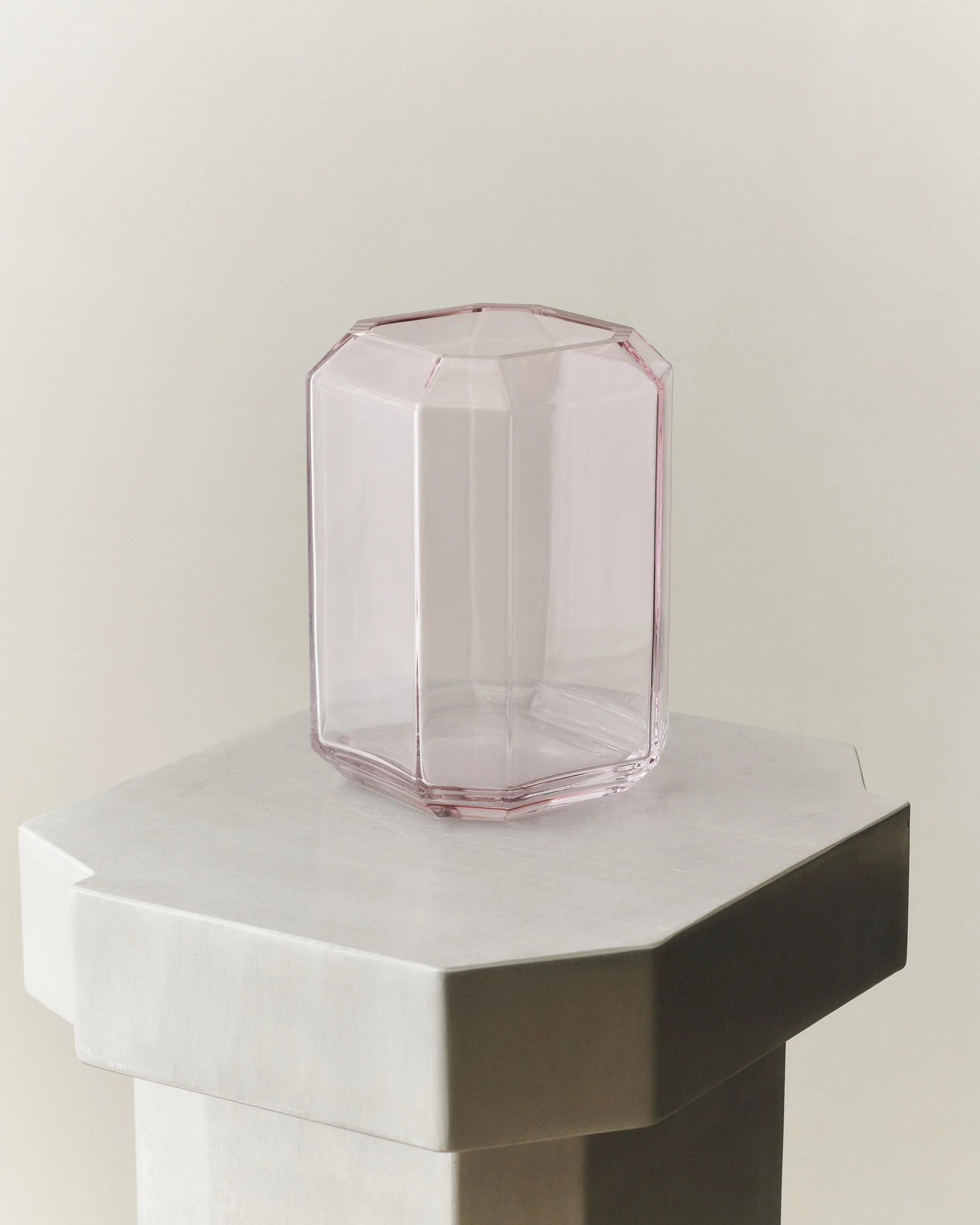 En vacker formad rosa vas på ett vitt bord