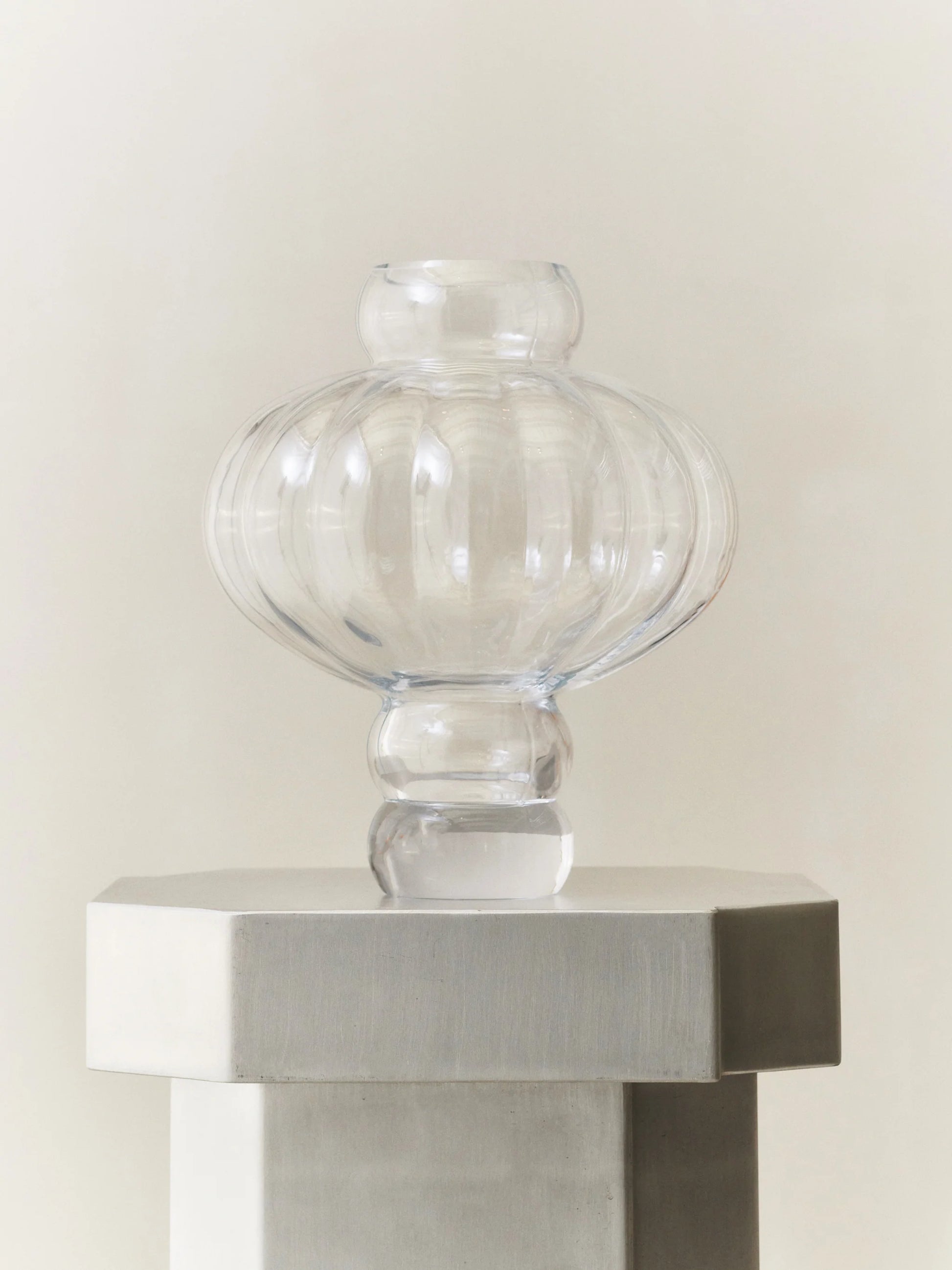 En vacker runt formad vit vas på ett vitt bord