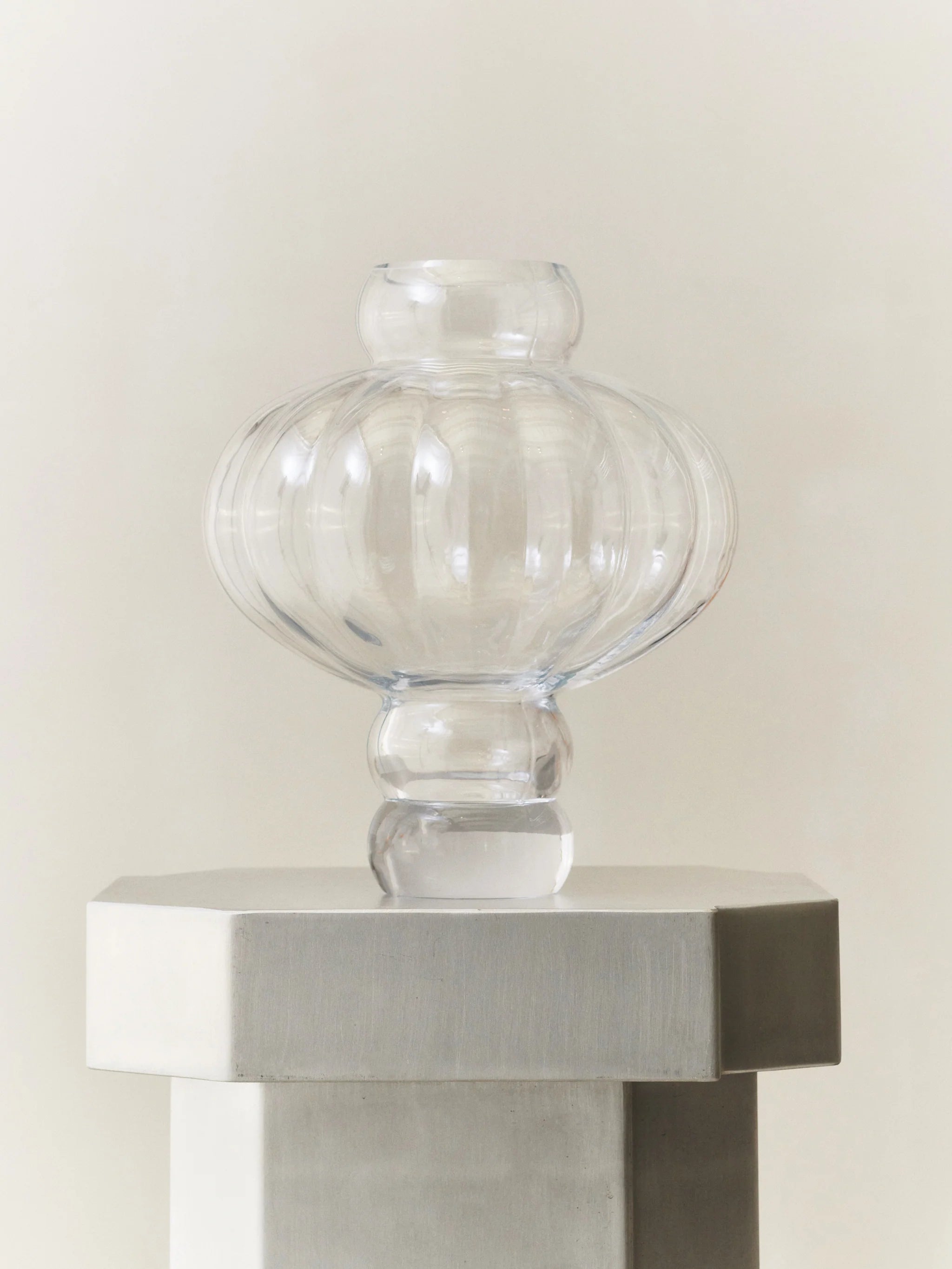 En vacker runt formad vit vas på ett vitt bord