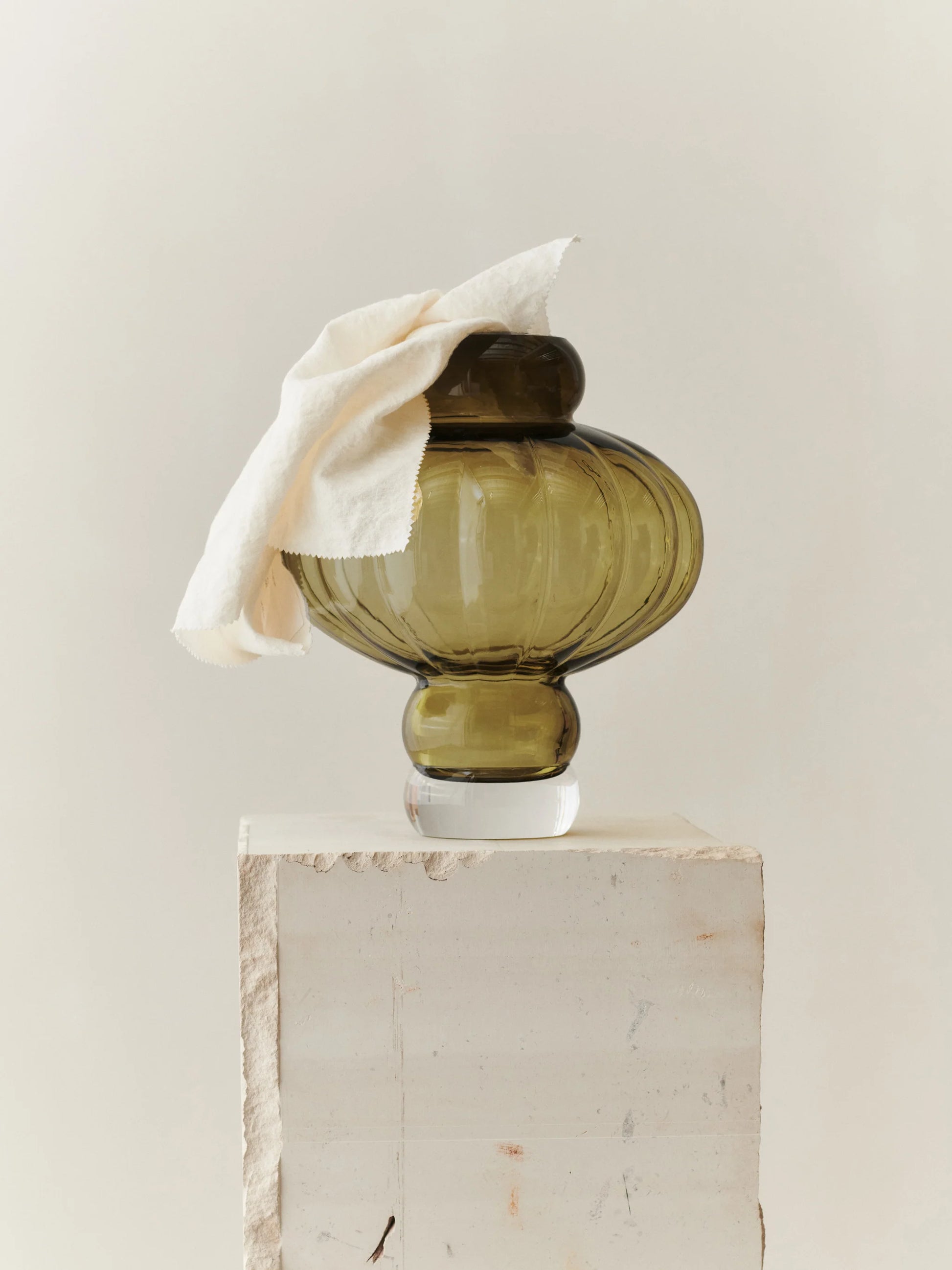 En vacker formad grön vas på ett vitt bord