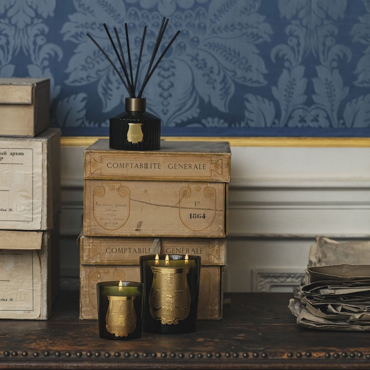 Doftljus och doftpinnar på ett bord med böcker och papper